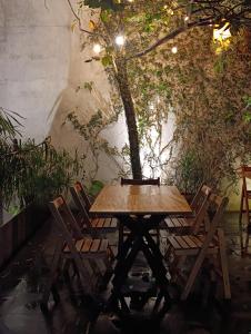 a wooden table and chairs sitting next to a tree at Nardazul "Casa de Sueños" in Oaxaca City