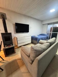 a living room with a couch and a flat screen tv at Deptosxdia in Perito Moreno