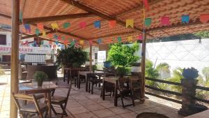 a restaurant with tables and chairs and colorful flags at Pousada Rosa dos Ventos in Genipabu