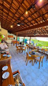 a restaurant with wooden tables and chairs and tablesearcher at Pousada das Saíras in Paraty