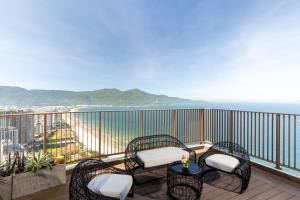 a balcony with chairs and a table and the ocean at Wyndham Soleil Danang - Free Schedule Airport Shuttle in Danang