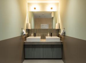 a bathroom with two sinks and a large mirror at 鈴木旅館 in Joetsu