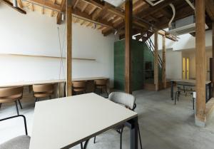 an empty room with tables and chairs in a building at 鈴木旅館 in Joetsu