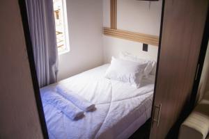 a bedroom with a bed with white sheets and pillows at Aparta estudio in Itagüí