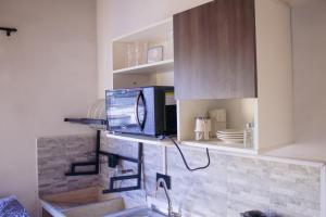 a kitchen with a tv sitting on a shelf at Aparta estudio in Itagüí +8 photos
