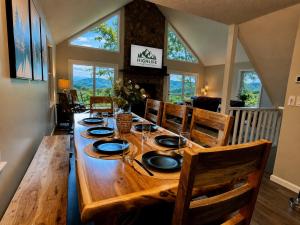 a long wooden table in a room with windows at Above the Clouds Cabin in Franklin