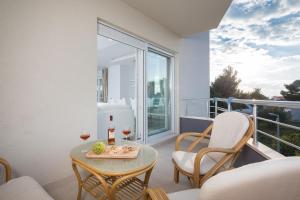 a balcony with a table and glasses of wine at The Adriatic Pearl Split in Podstrana