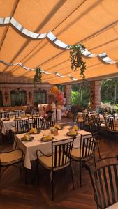 a dining room with tables and chairs under a tent at Hotel Sumski Feneri in Trnovo