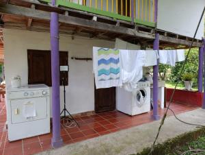 a house with a washing machine and a clothes line at Finca de las banderas in Jardin