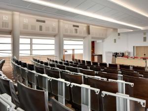 an empty lecture hall with black chairs in it at Mercure Montpellier Centre Comédie in Montpellier