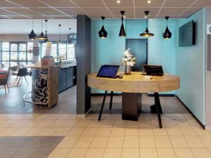 ein Büro mit einem Tisch, auf dem ein Laptop steht in der Unterkunft ibis Dinant Centre in Dinant