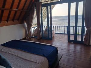 a bedroom with a bed and a view of the ocean at Amed Santorini Villa in Amed