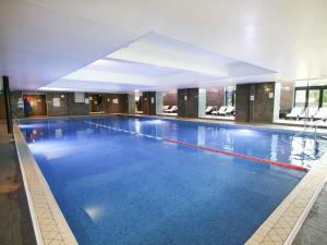a large swimming pool in a large building at Old Thorns Golf Resort And Spa Hampshire by Accor in Liphook