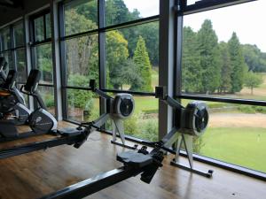 a gym with a view of a golf course through the windows at Old Thorns Golf Resort And Spa Hampshire by Accor in Liphook