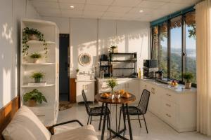 a kitchen with a table and chairs in a room at THỎ NON GARDEN CLOUDY OCEAN VIEW in Blao Srê