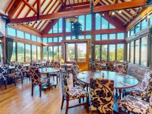 a dining room with tables and chairs and windows at Old Thorns Golf Resort And Spa Hampshire by Accor in Liphook