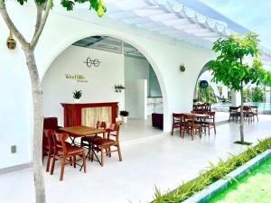 a dining area with tables and chairs in a building at homestay windhills in Ấp Nhơn Hòa