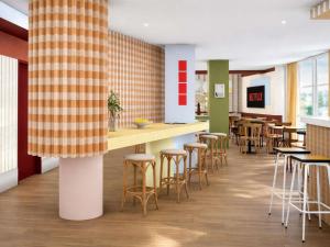 a bar in a restaurant with stools and tables at Greet Lourdes Centre Pyrenees in Lourdes
