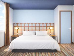 a bedroom with a large bed with white sheets at Greet Lourdes Centre Pyrenees in Lourdes