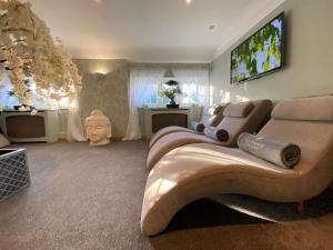 a living room with a couch and a flat screen tv at Old Thorns Golf Resort And Spa Hampshire by Accor in Liphook