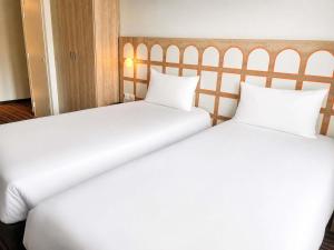 two beds in a hotel room with white sheets at Greet Lourdes Centre Pyrenees in Lourdes +8 photos