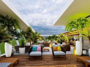 a patio with chairs and palm trees in a building at IBIS LAGOS LEKKI in Lagos