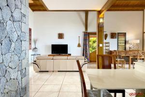 a living room with a television and a table at Villa TheOceane in Les Avirons