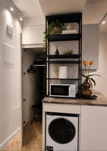 a kitchen with a microwave on a counter at Mažvydo Alėjos Self Check-In in Klaipėda