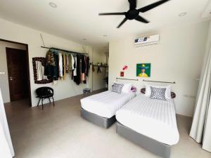 a bedroom with two beds and a ceiling fan at VILLA 3 CHAMBRES a partager in Nathon Bay +3 photos