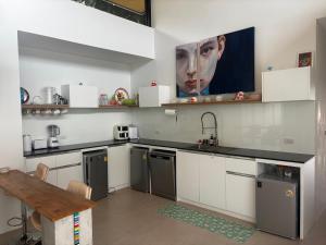 a kitchen with a painting of a man on the wall at VILLA 3 CHAMBRES a partager in Nathon Bay