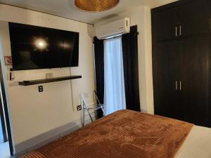 a bedroom with a bed and a flat screen tv at Modern Apartment in Rosarito +4 photos