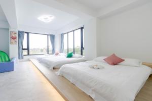two beds in a white room with large windows at ZJ Villa in Sanxing