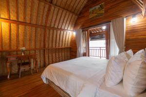 a bedroom with a bed and a table in a room at Villa Darma Ubud by Bali Cabin in Ubud +9 photos