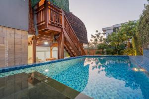 a house with a swimming pool with a staircase above it at Villa Darma Ubud by Bali Cabin in Ubud