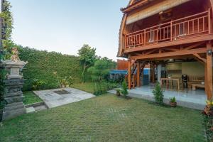 a house with a yard with a patio at Villa Darma Ubud by Bali Cabin in Ubud