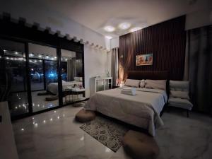 a bedroom with a large bed and a chair in it at Buddy's Skybar & Suite in Guinsorongan