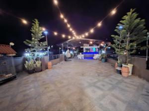 a patio at night with potted plants and lights at Buddy's Skybar & Suite in Guinsorongan