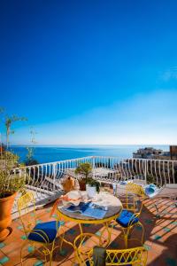 a patio table with chairs and umbrellas on a beach at Hotel Villa Delle Palme in Positano in Positano