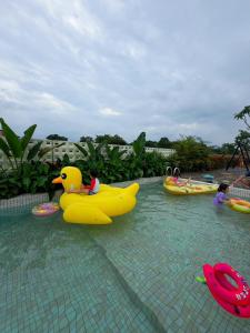 a pool with a rubber duck and children in inflatable boats at ZJ Villa in Sanxing