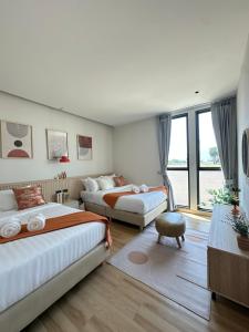 a bedroom with two beds and a living room at April Pool Day Villa Cha-am in Cha Am