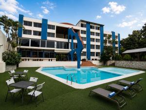 a building with a swimming pool and chairs and a building at Hotel Tepoztlán in Tepoztlán