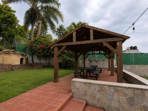 a wooden pavilion with tables and chairs in a yard at Hotel Tepoztlán in Tepoztlán
