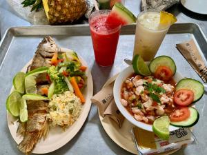 a tray with two plates of food and a drink at Hotel Miraflores in El Cuco