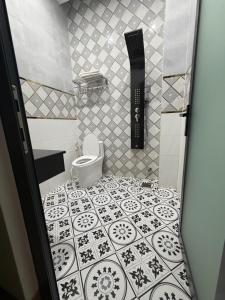 a bathroom with a toilet and a tiled floor at Thảo Tiên Vị Thanh in Xóm Tràm Cửa