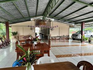 a restaurant with tables and chairs and a car parked at Cabinas del Río in Upala