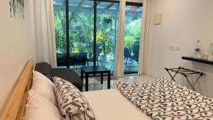 a bedroom with a bed and a large window at Oceana Surf Maldives - Kudahuvadhoo Island Surf Retreat in Kudahuvadhoo