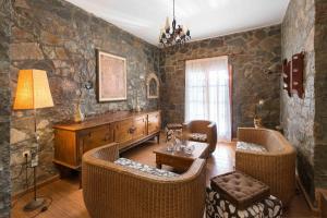 a living room with stone walls and wicker chairs at Villa Zoi in Gennadi