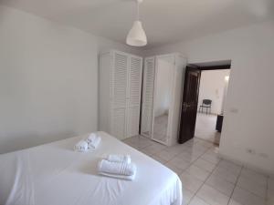 a white bedroom with a bed with towels on it at Casa Francesca Ponza in Ponza
