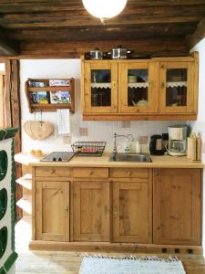 eine Küche mit Holzschränken und einem Waschbecken in der Unterkunft Romantikzimmer Jakobbauer in Turnau