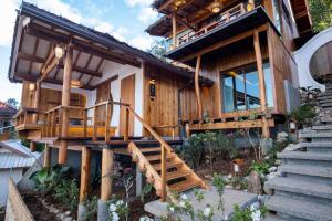 a wooden house with stairs leading up to it at Wojia我家 in Ban Rak Thai